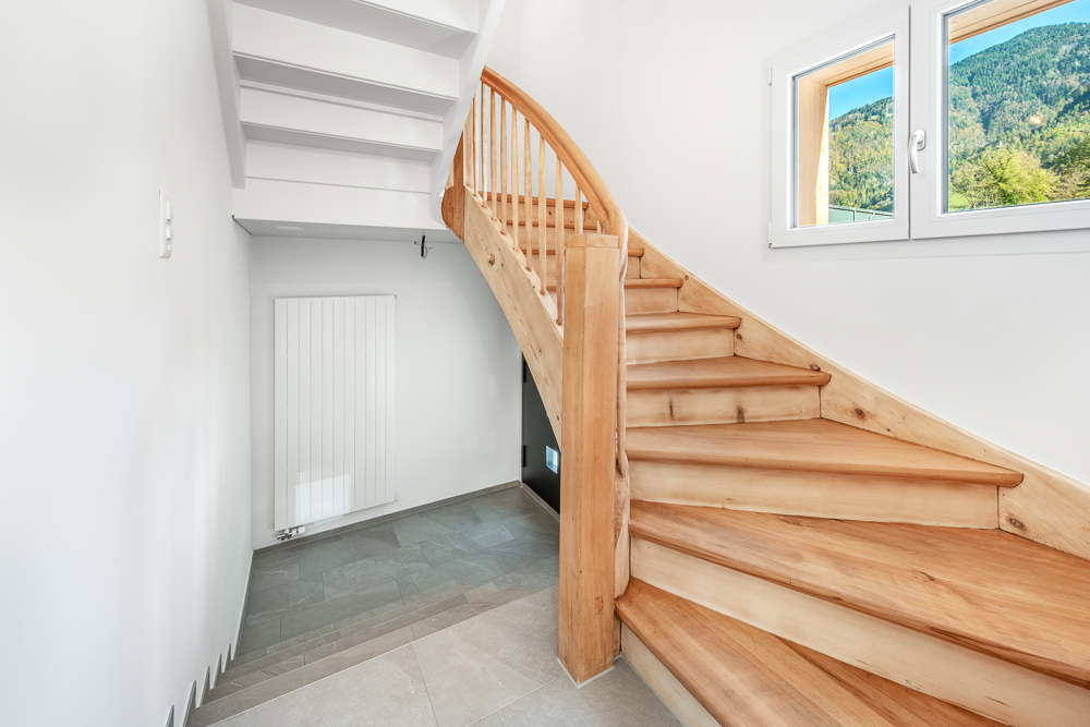 Treppe im hellen Flur mit Bergblick