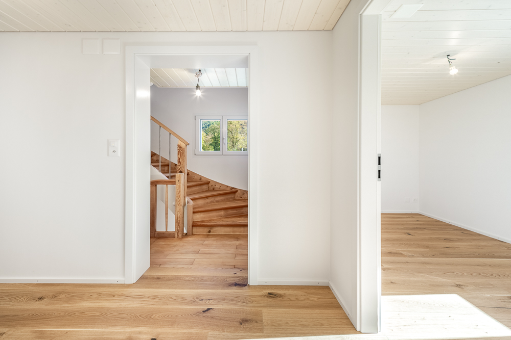 Heller Flur mit Treppe und angrenzendem Raum