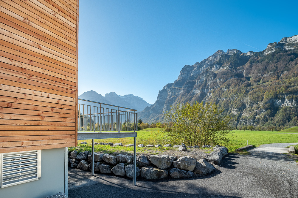 Außenansicht eines Holzgebäudes mit Bergpanorama