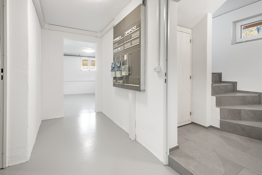 Heller Flur mit Treppe und Elektroverteiler