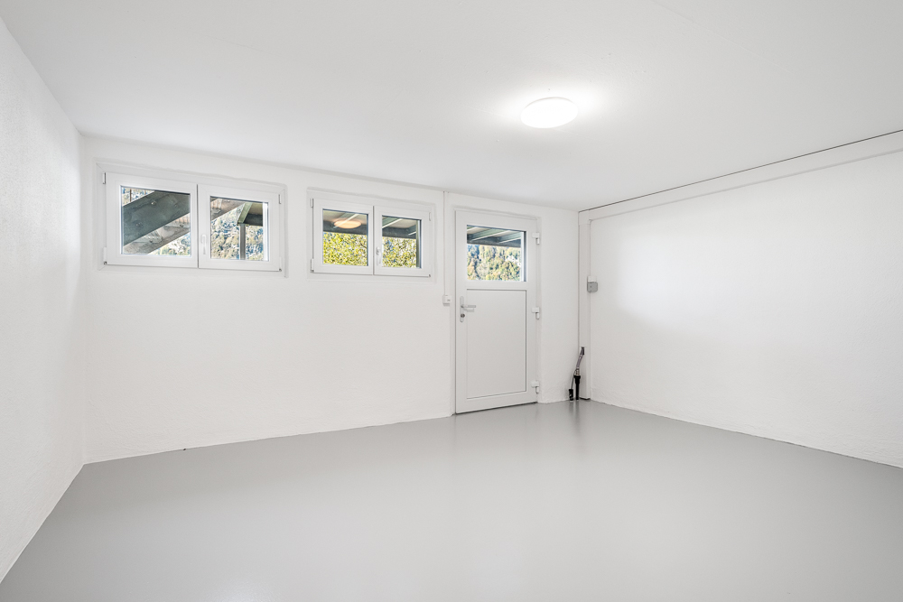 Leerer heller Raum mit kleinen Fenstern und Tür