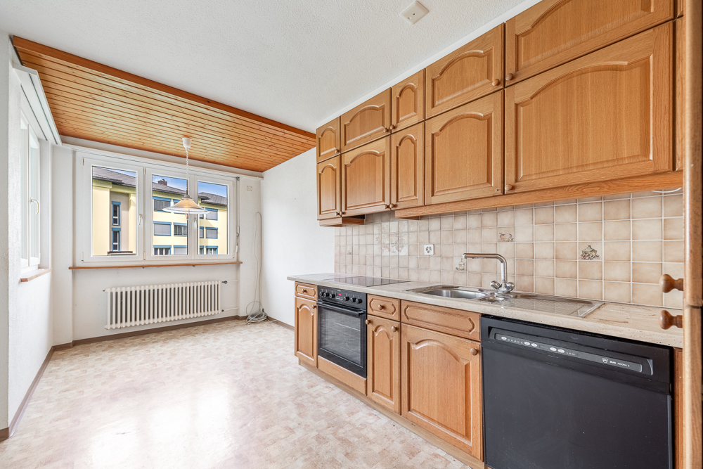 Küche mit Holzfronten und großem Fenster