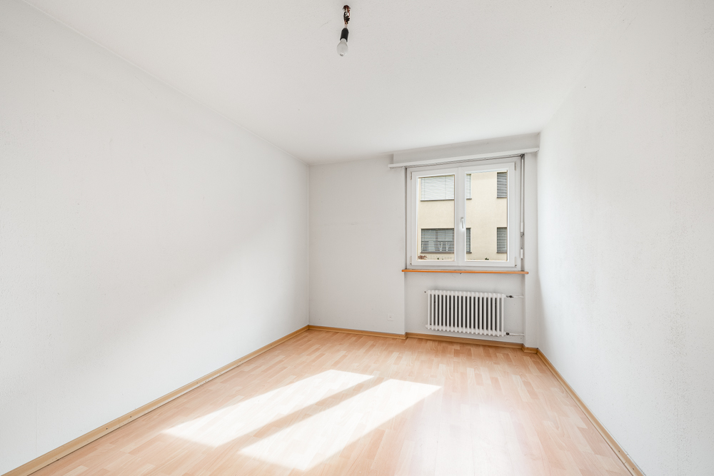 Leerer heller Raum mit Fenster und Heizkörper