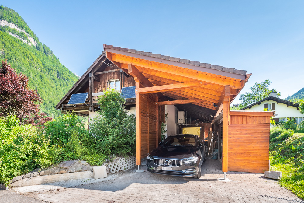Überdachter Carport vor einem Chalet