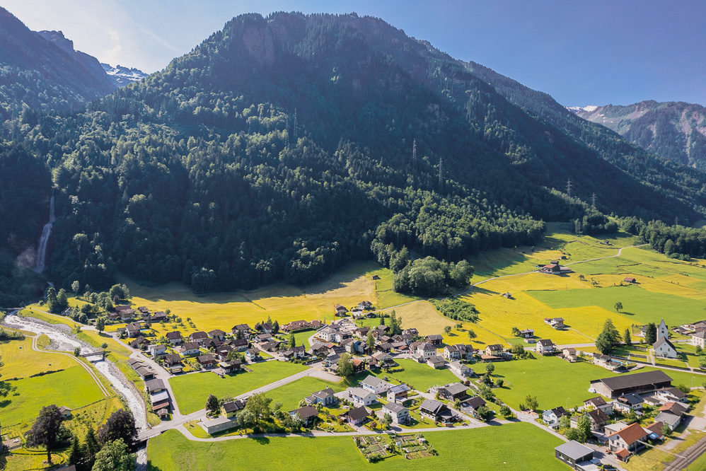 Luftaufnahme eines Alpentals mit Siedlung
