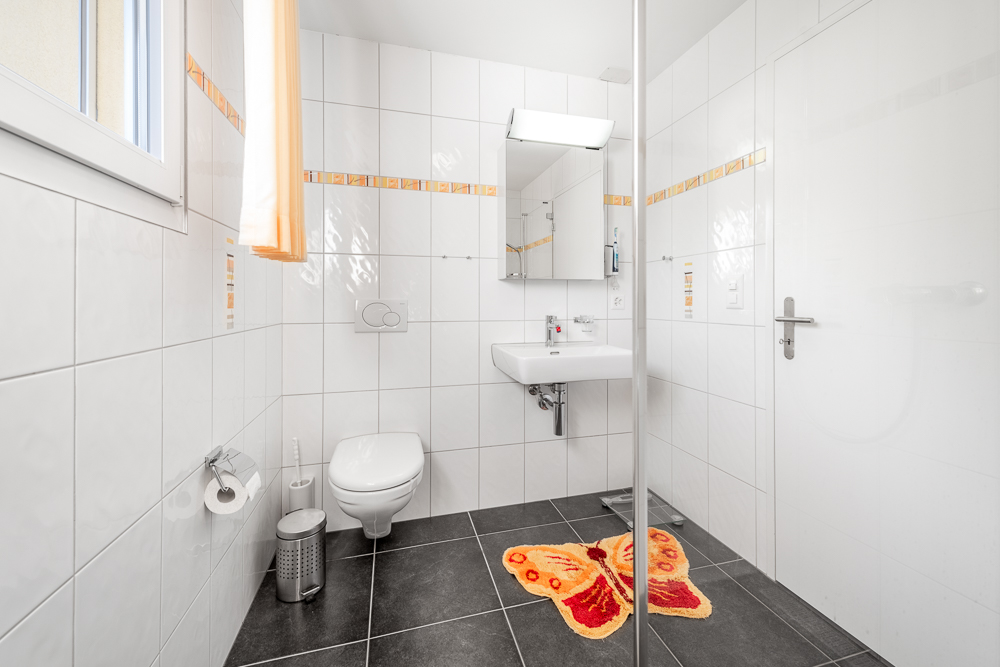 Kleines, helles Badezimmer mit WC und Waschbecken