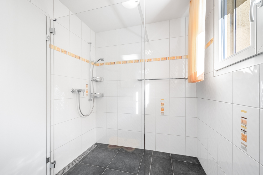 Helle moderne Dusche mit Glasabtrennung