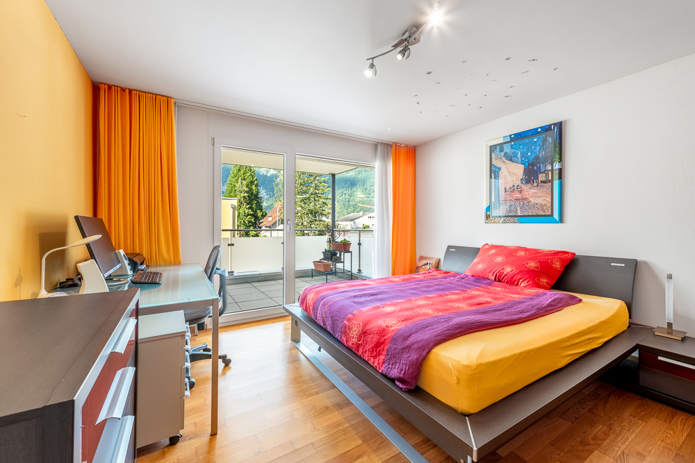 Helles Schlafzimmer mit Balkon und Arbeitsplatz