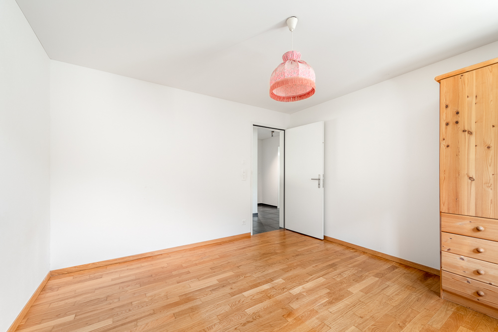 Helles, leeres Schlafzimmer mit Holzboden