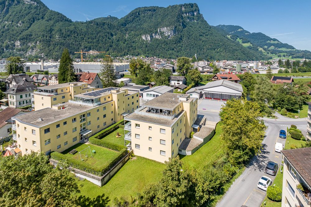 Luftaufnahme eines Wohnquartiers mit Bergkulisse
