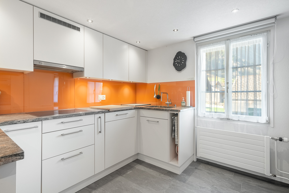 Moderne Küche mit orangefarbener Rückwand