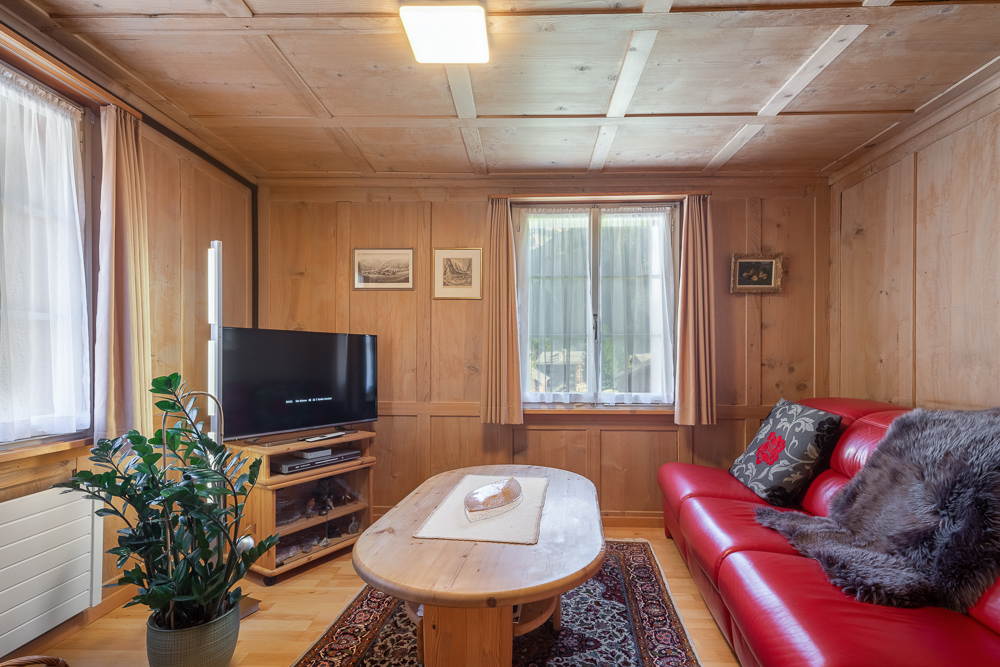 Gemütliches Holzwohnzimmer mit rotem Sofa