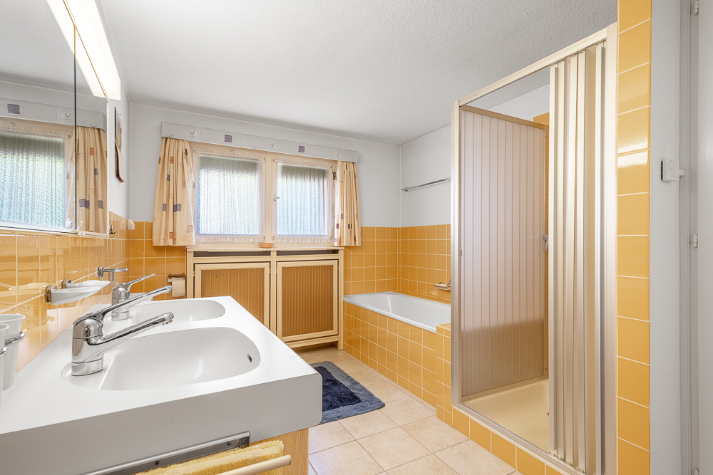 Badezimmer mit gelben Fliesen und Doppelwaschbecken