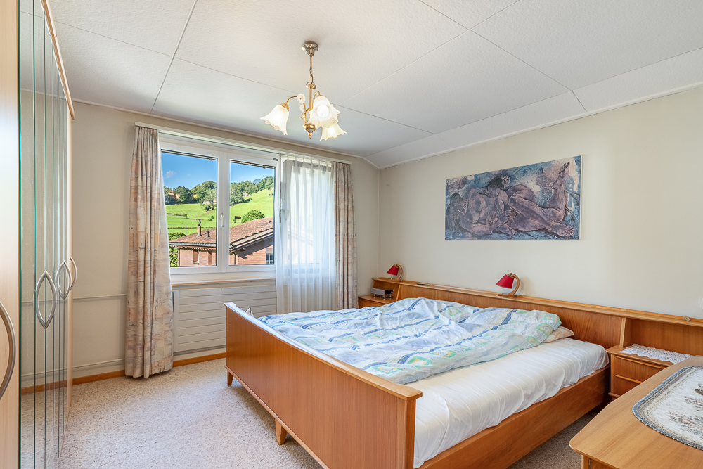 Schlichtes Schlafzimmer mit Ausblick ins Grüne