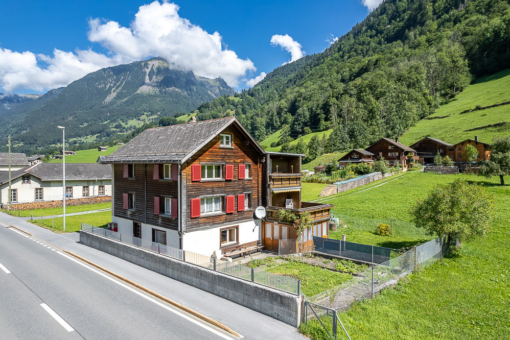 Berghaus mit Holzfassade in alpiner Landschaft
