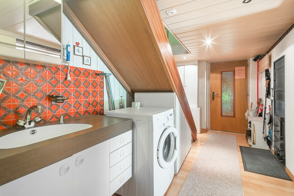 Dachgeschoss-Haushaltsbereich mit Waschbecken und Waschmaschine