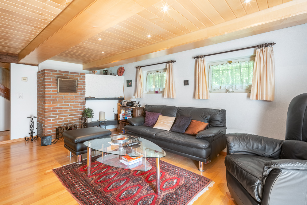 Wohnzimmer mit Holzdecke und Ziegelkamin