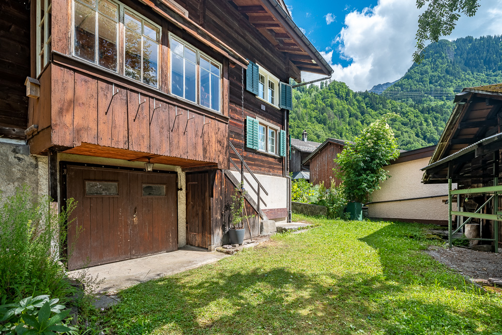 Traditionelles Haus mit Garten und Bergkulisse