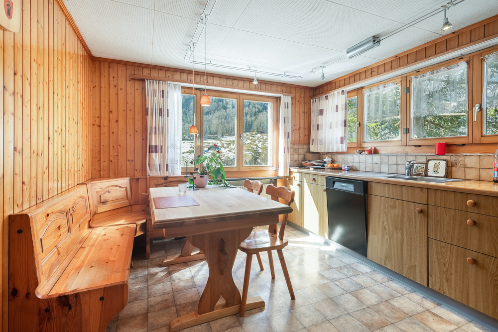 Gemütliche Küche mit Holzvertäfelung und Essplatz