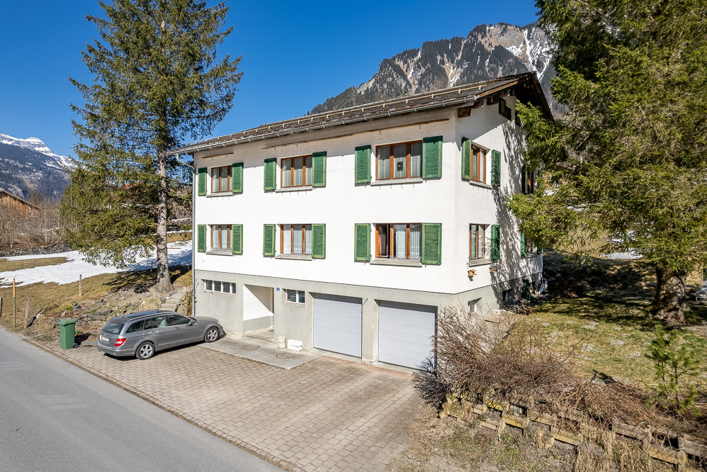 Alpines Wohnhaus mit grünen Fensterläden