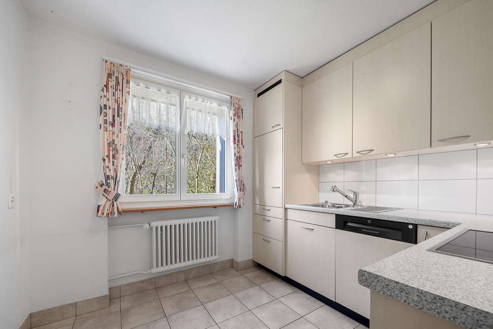 Helle Einbauküche mit Fenster und Heizkörper