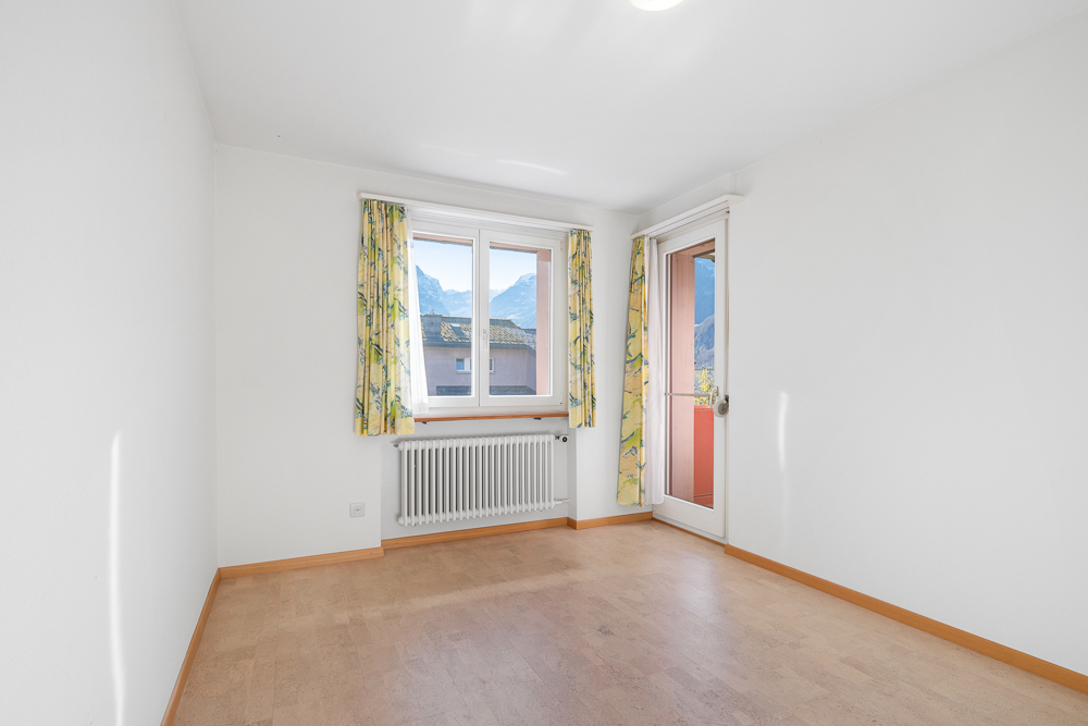 Leerer heller Raum mit Balkon und Bergblick