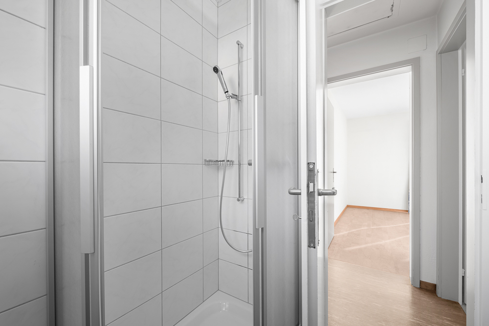 Badezimmer mit Dusche und Blick in den Flur