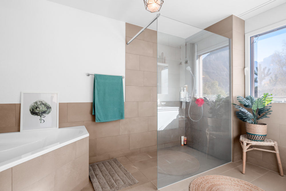 Helles Badezimmer mit Badewanne und Glasdusche