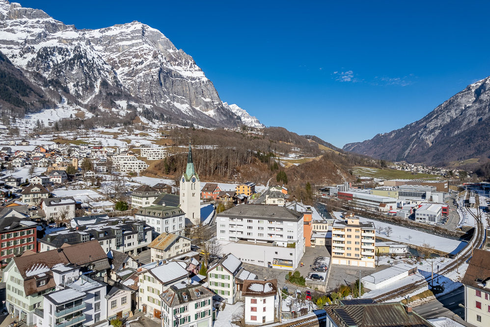 Alpenstädtische Luftaufnahme mit verschneitem Tal