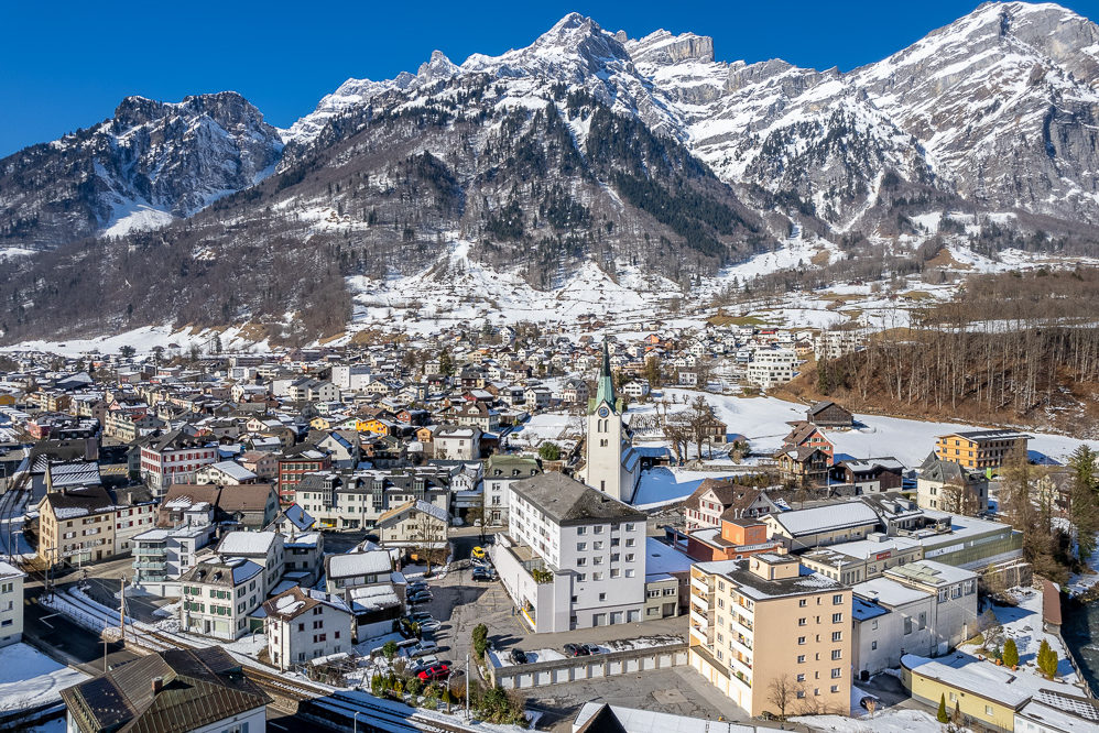 Winterliche Alpenstadt mit Bergpanorama