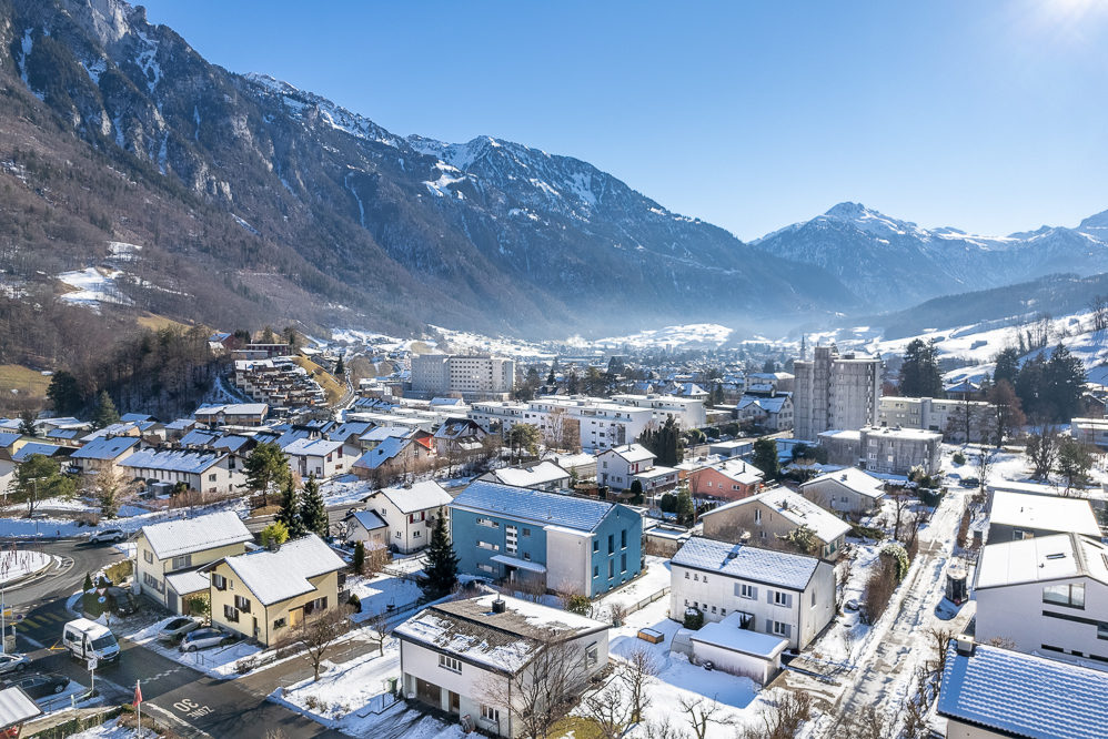 Bergpanorama über eine verschneite Wohnsiedlung