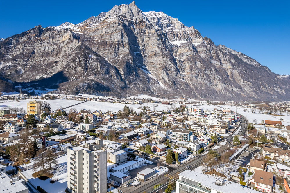 Schneebedeckte Alpenstadt mit Großgipfel