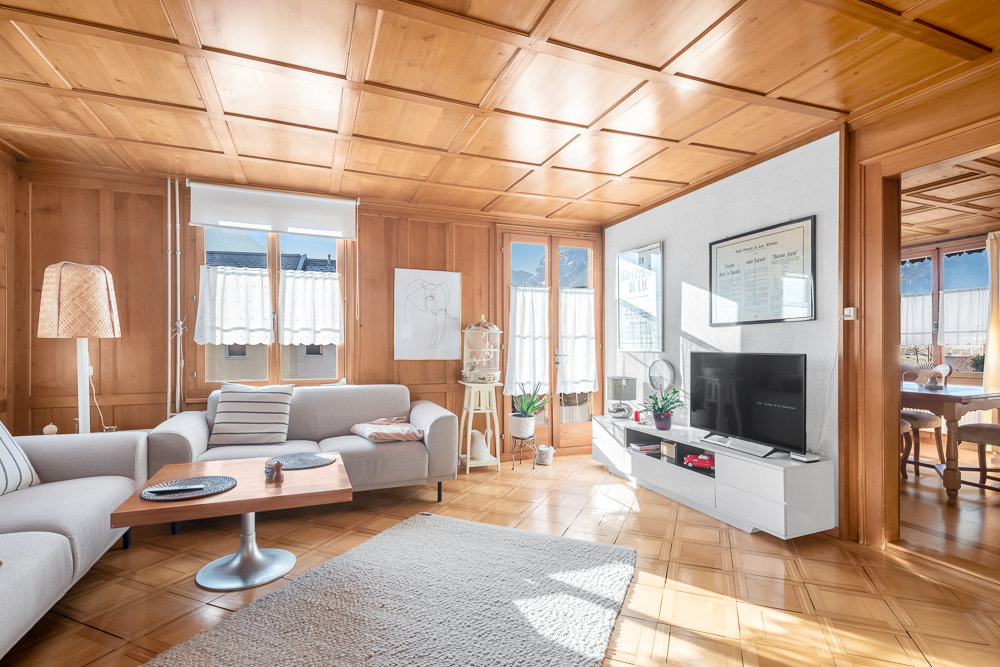 Wohnzimmer mit Holzvertäfelung und viel Tageslicht