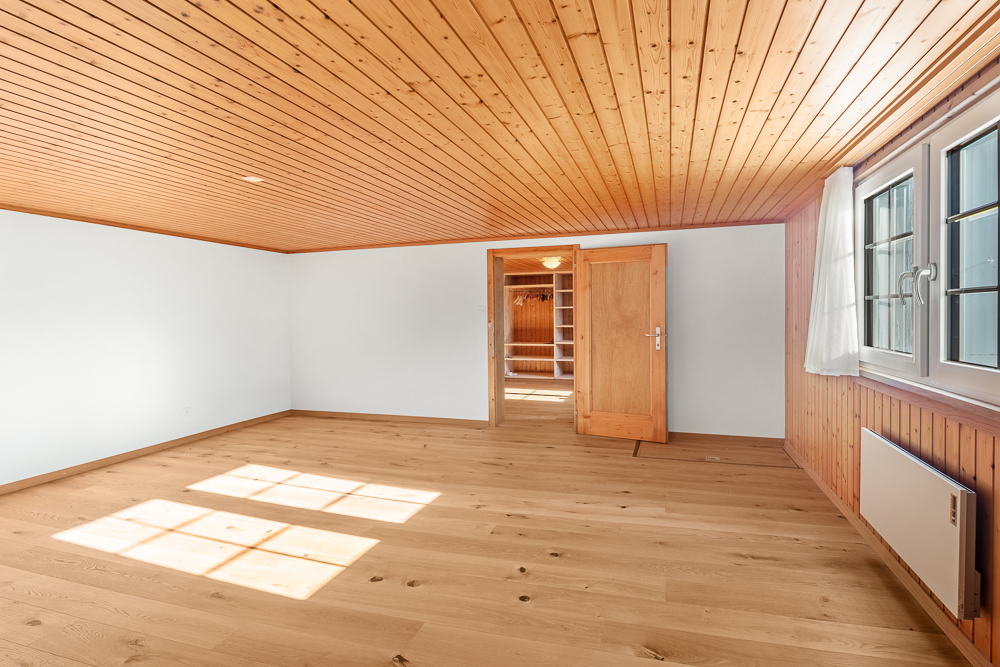 Leerer heller Raum mit Holzdecke und Parkett
