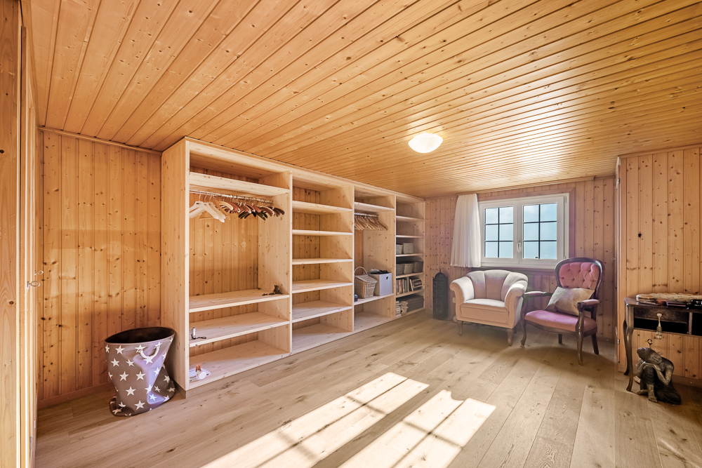 Holzverkleideter Raum mit Kleiderschrank und Sitzbereich