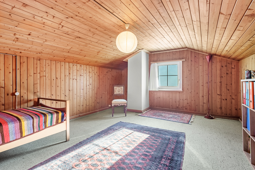 Gemütliches Dachzimmer mit Holzvertäfelung