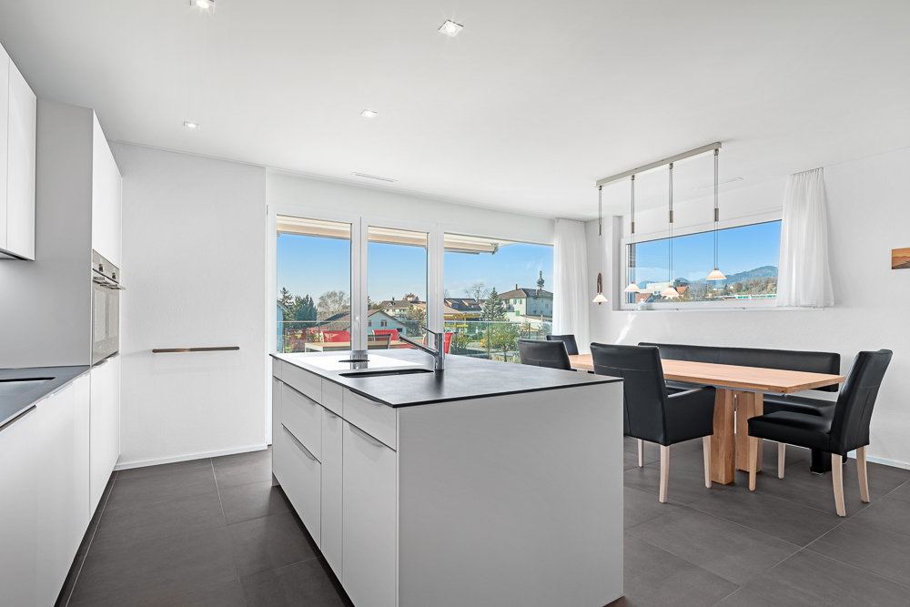 Moderne offene Küche mit Essbereich und Ausblick