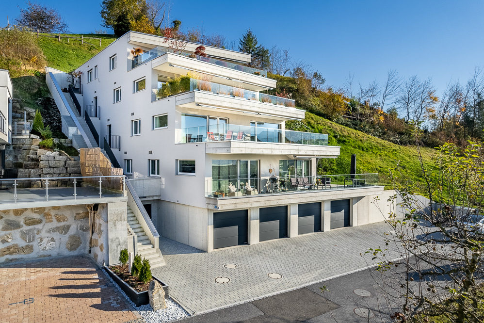 Modernes Mehrfamilienhaus am Hang mit Terrassen und Garagen