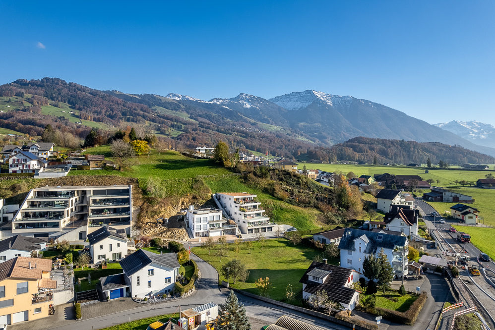 Panoramablick auf eine alpine Wohnsiedlung mit Bergen