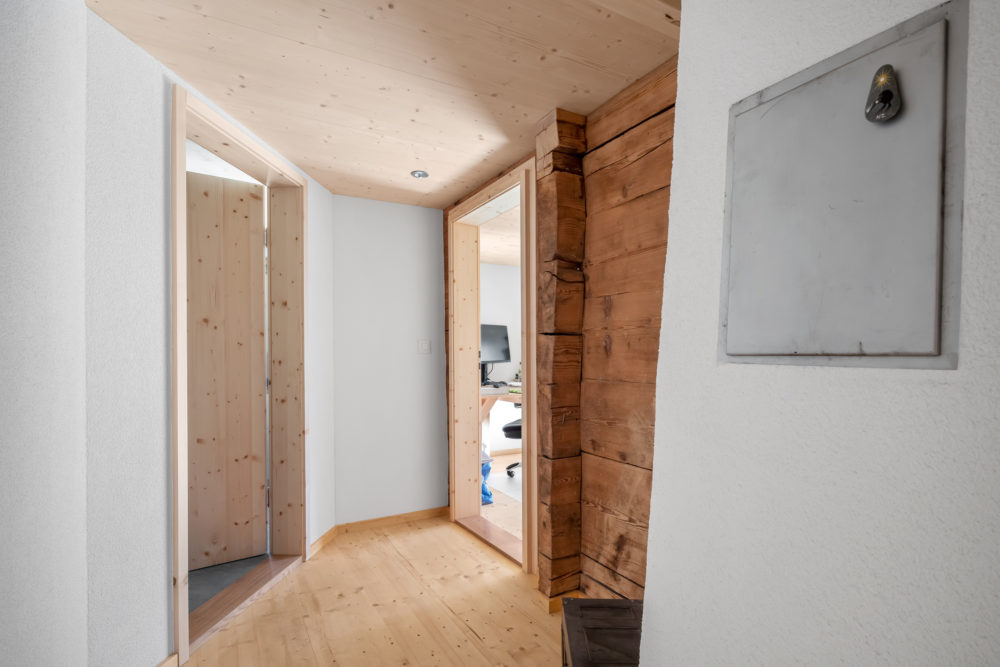 Heller Flur mit Holzdecke und sichtbaren Massivholzelementen
