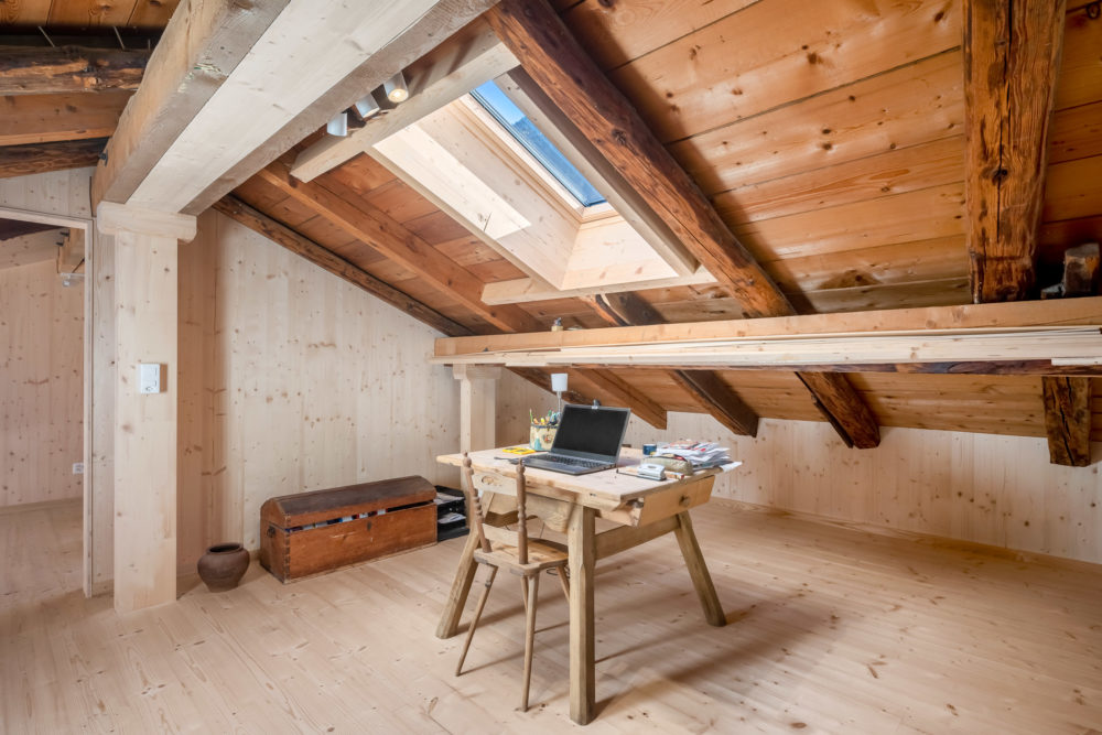 Dachbodenbüro mit sichtbaren Holzbalken