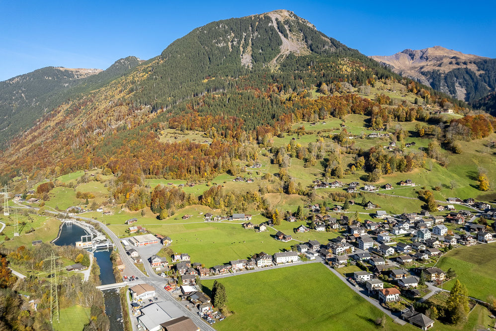 Alpenort mit Tal, Fluss und Bergkulisse