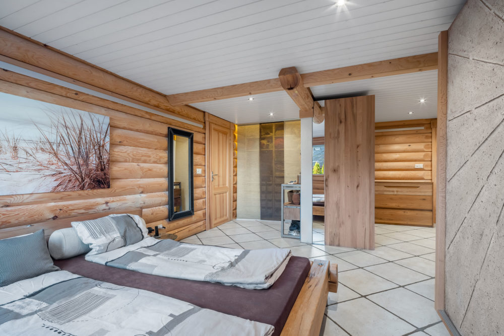 Rustikales Schlafzimmer mit Holzblockwänden