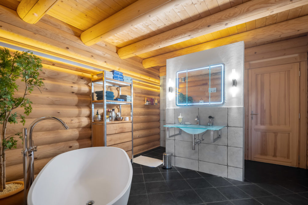 Holzverkleidetes Badezimmer mit freistehender Wanne