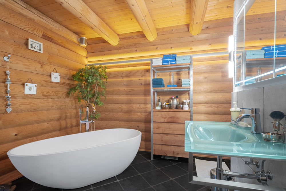 Badezimmer mit Holzverkleidung und freistehender Wanne