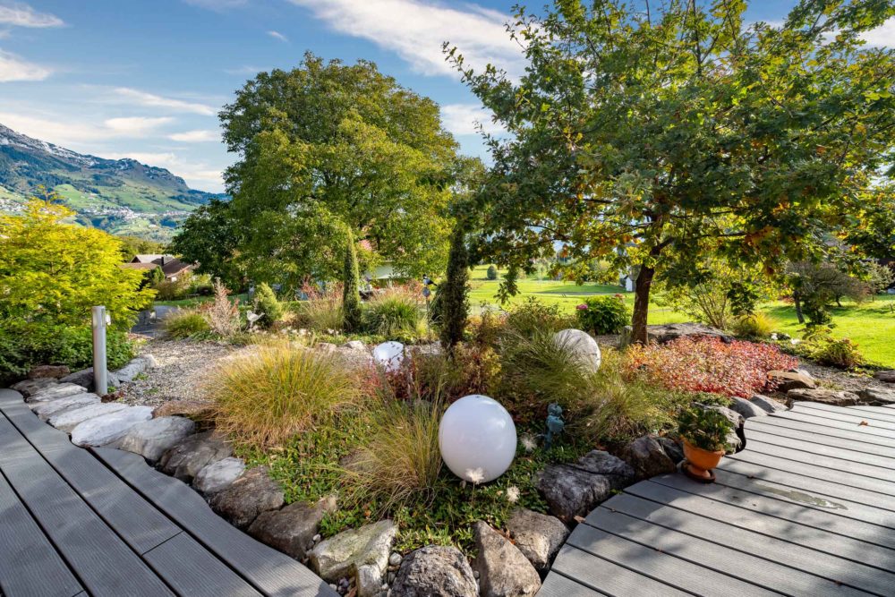 Blick in einen gepflegten Garten mit Bergpanorama
