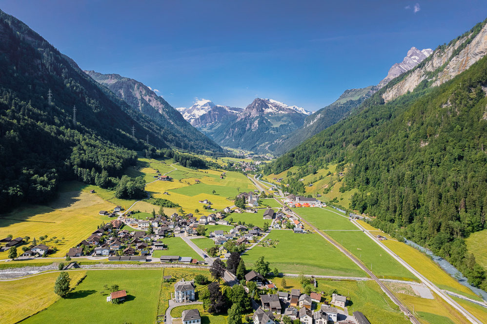 Alpen-Talansicht mit Dorf und Bergen