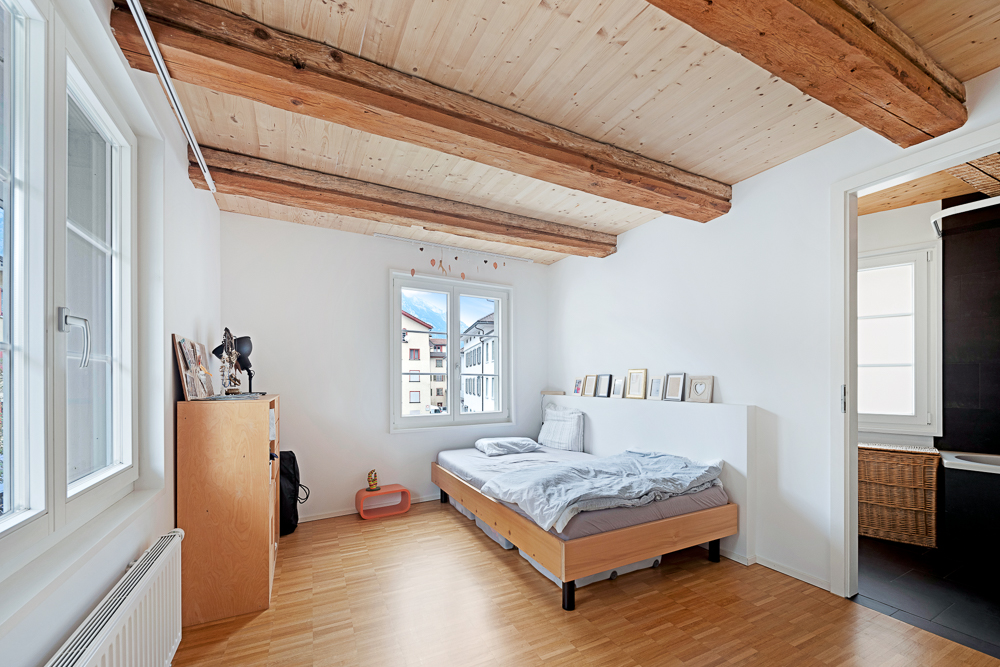Helles Schlafzimmer mit sichtbaren Holzbalken