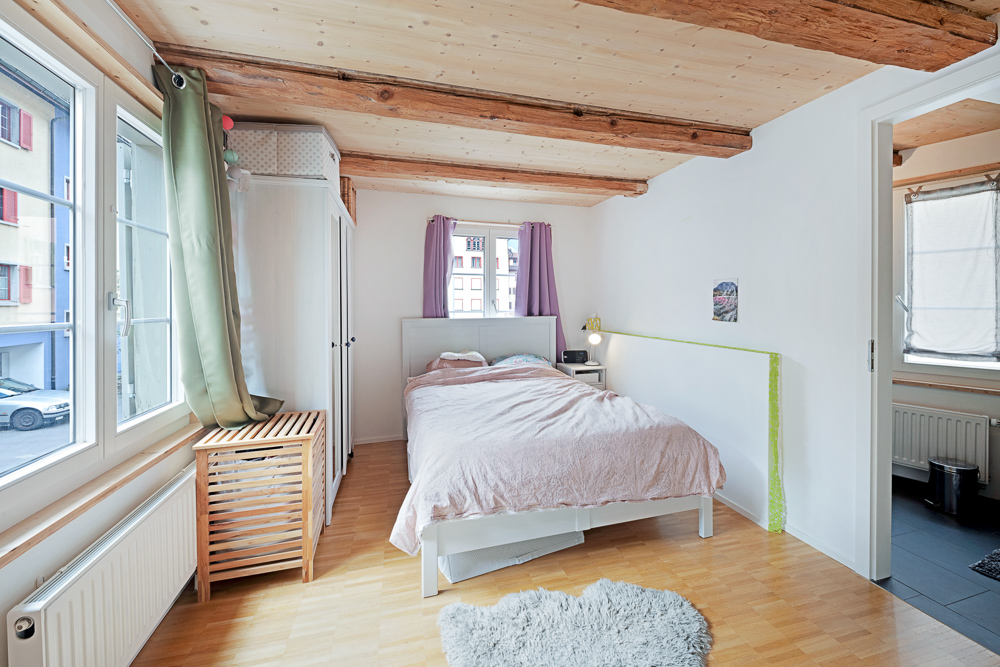 Helles Schlafzimmer mit sichtbaren Holzbalken