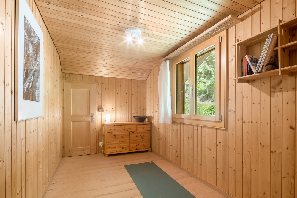 Holzvertäfelter Raum mit Fenster und Schrank